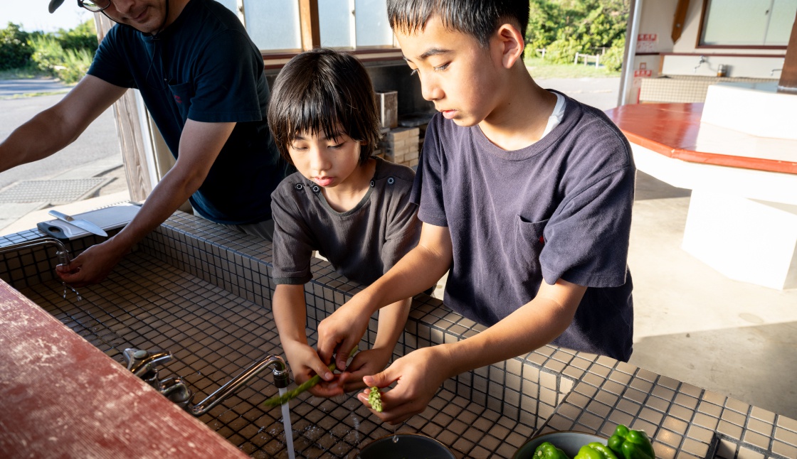 炊事棟で野菜を洗う子どもたち